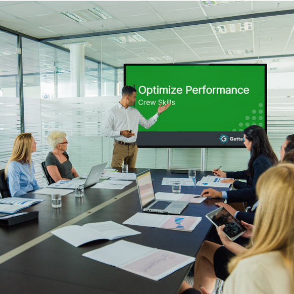 A man introducing the meeting module video on a screen in a conference room of employees.